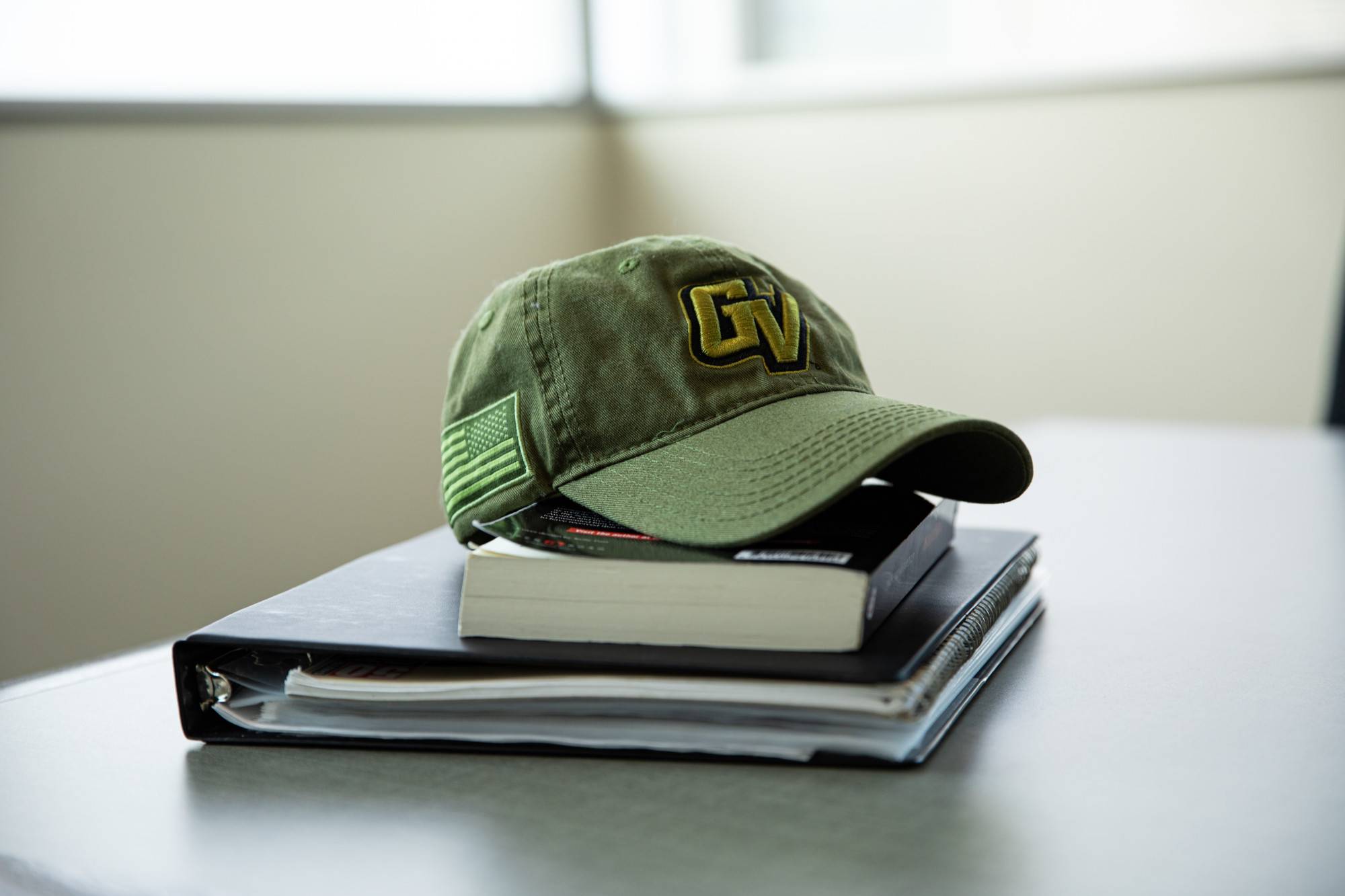 Vet Green Hat on top of books